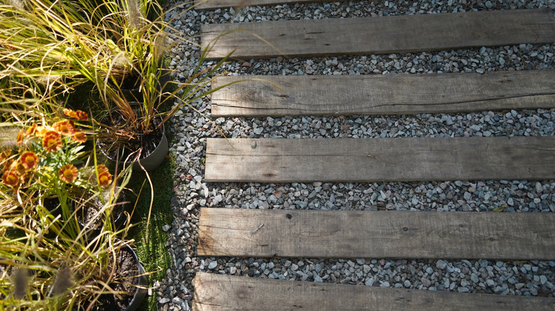 A walkway made with spaced wood pallets with gravel in between