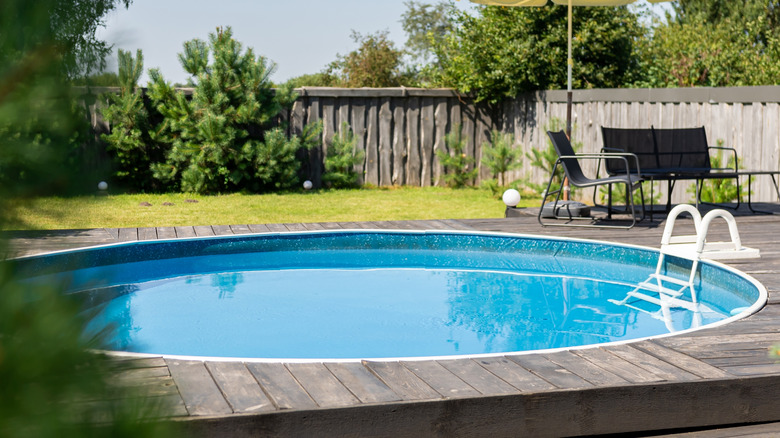 Backyard pool surrounded by wooden decking