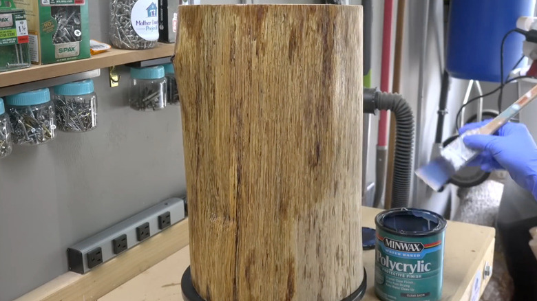 DIY tree stump table being sealed with Polycrylic