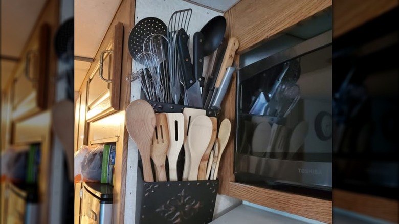 A mail holder repurposed into a utensil holder