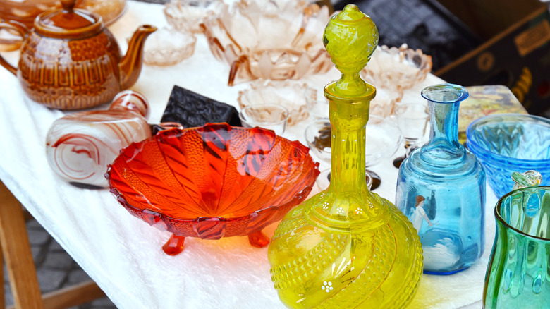 Miscellaneous pieces of vintage and antique glass on a display table.