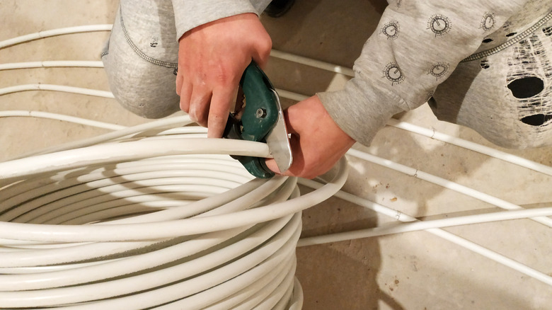 Someone cutting white tubing