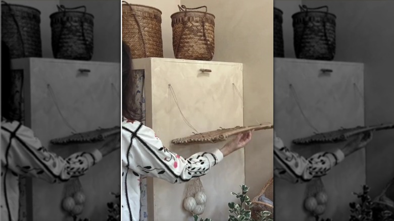 A laundry rack made from a vintage French baking rack being held by a person