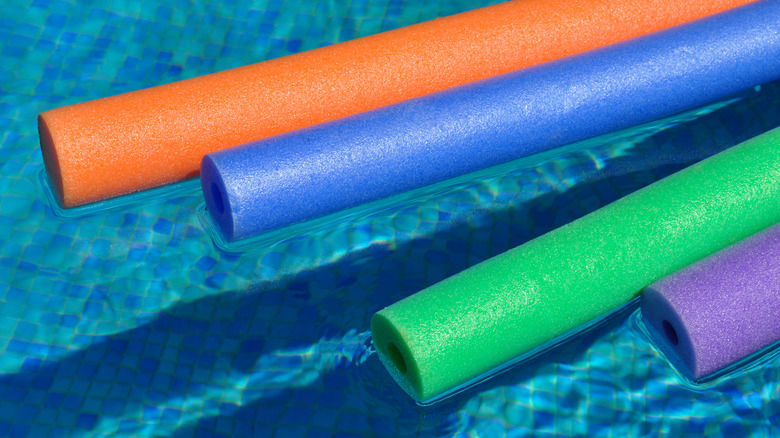 Four pool noodles floating in water