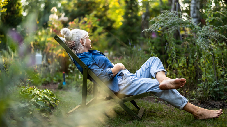 Woman in a lounge chair relaxing in her garden