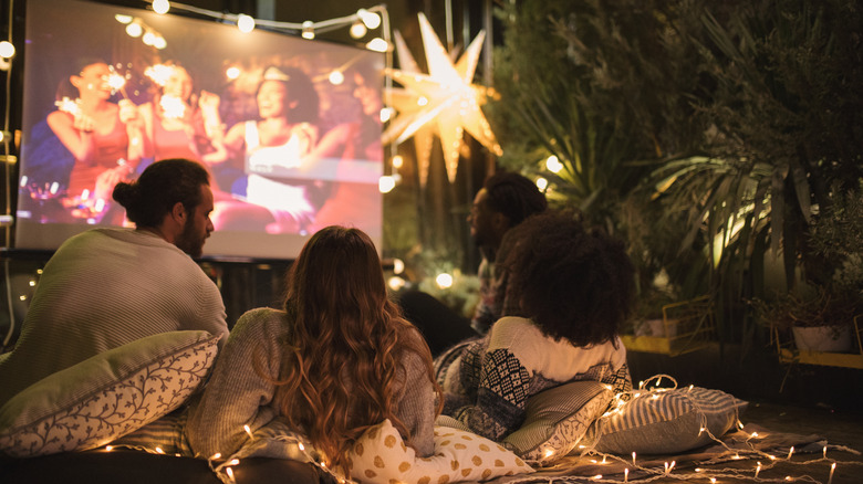 Friends watching projector outdoors