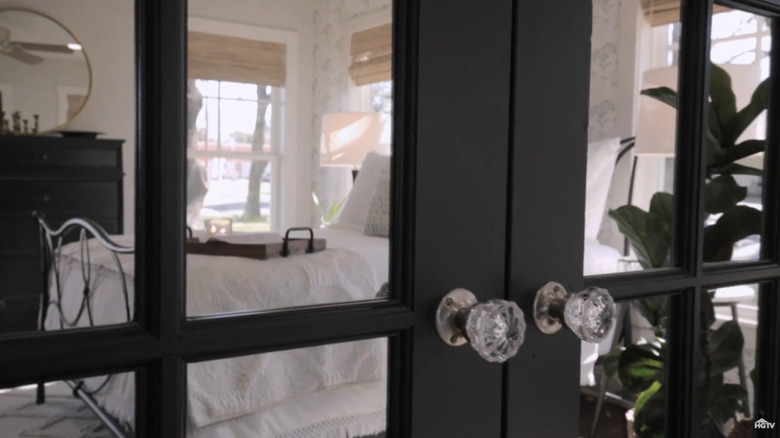 Black French closet doors with mirrored paneling in light bedroom