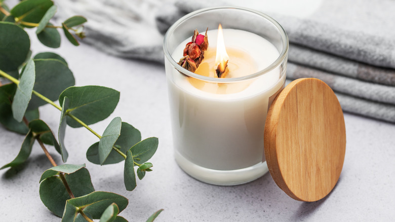 candle and eucaplytus on bed