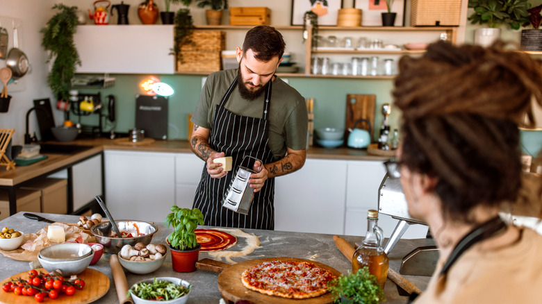 A couple making pizza in their home kitchen