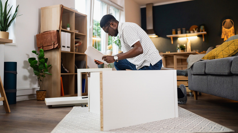 person assembling ikea shelves