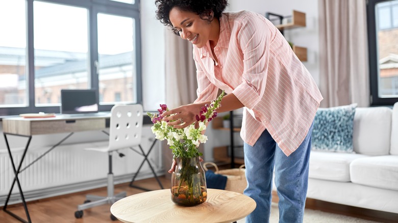 Someone arranging flowers in vase