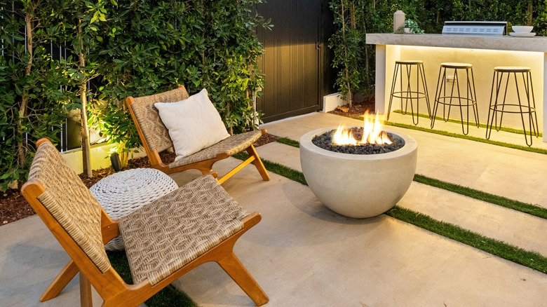 Patio featuring a natural stone firepit, woven natural chairs, and bar counter