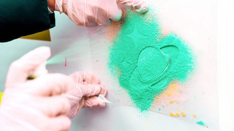 spray painting a planet with a green stencil
