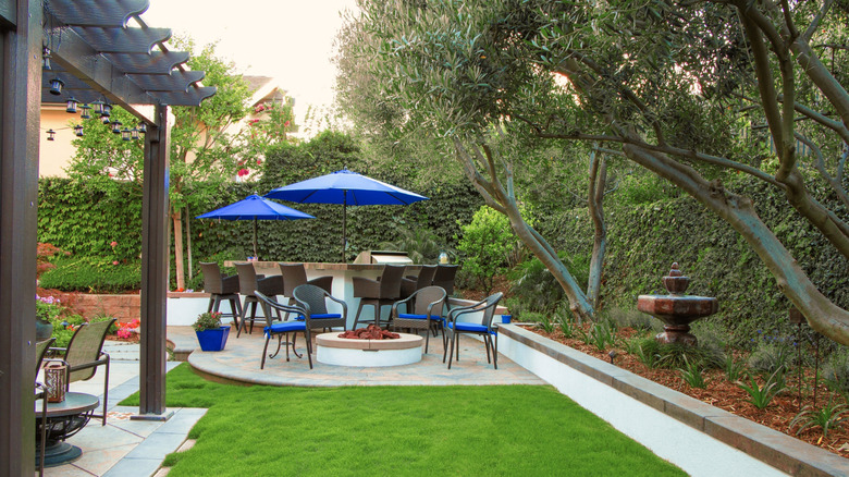A backyard oasis with outdoor seating and a lush, green lawn
