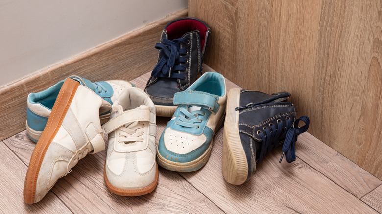Messy shoes in a corner of a room