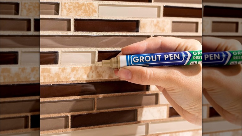 someone using a grout pen