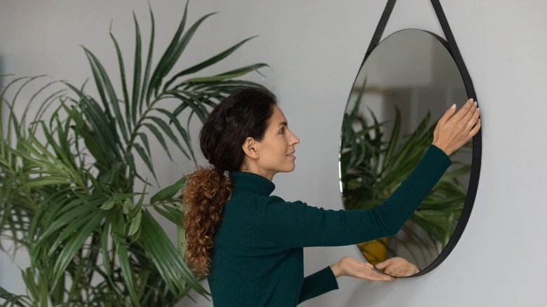 person hanging a mirror