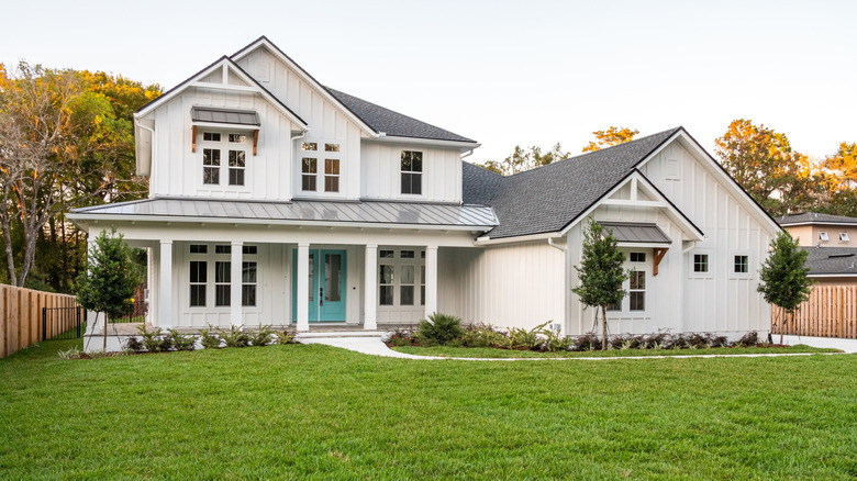 Beautiful finished white home with gray roof and green yard