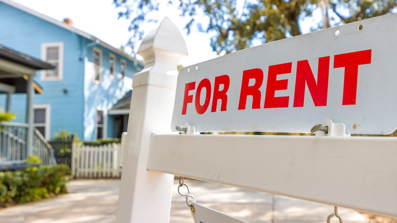 A for rent sign in front of home with red letters