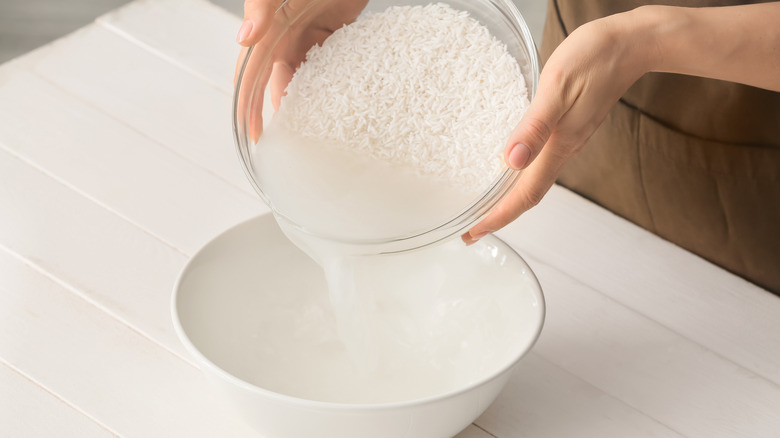 Straining water out of cooked rice into a bowl