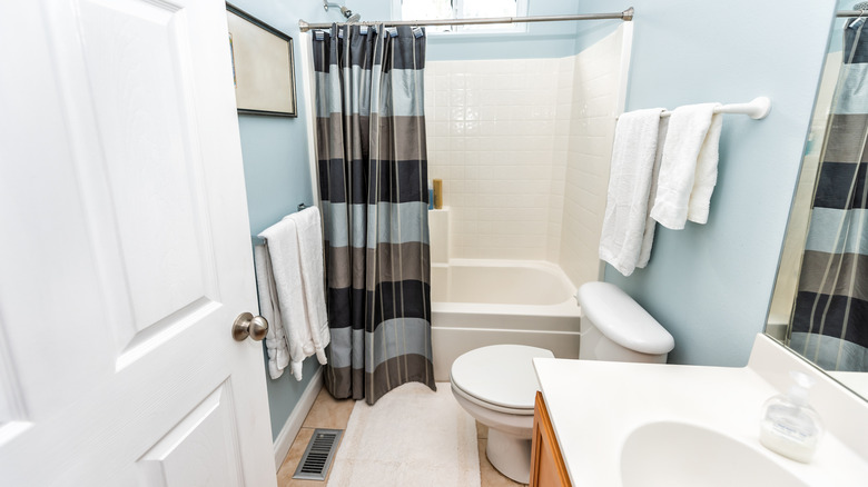 A small bathroom with two mismatched towel bars
