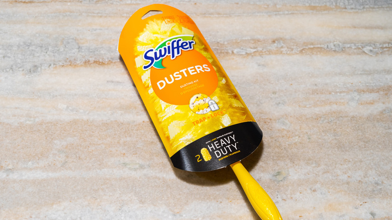 A Swiffer duster on a wood floor, still in its packaging