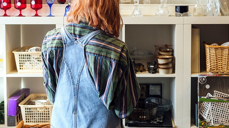 Close-up of a person's back looking at secondhand items on shelves