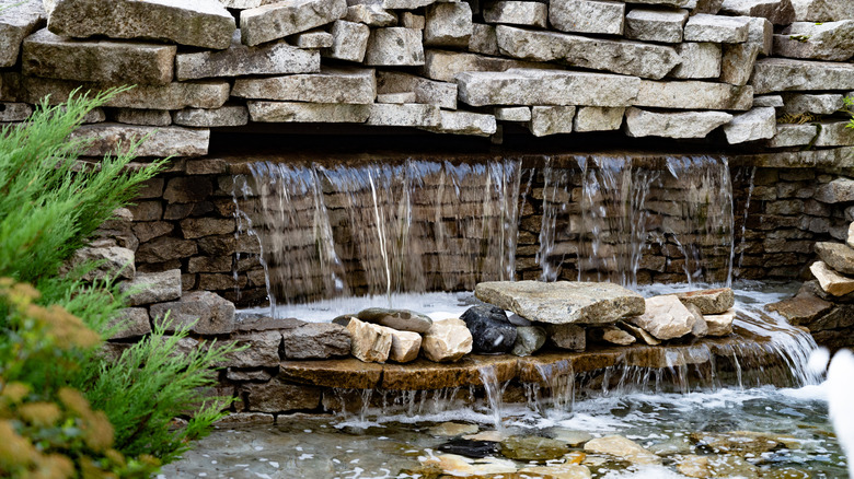 A rustic waterfall on a retaining wall