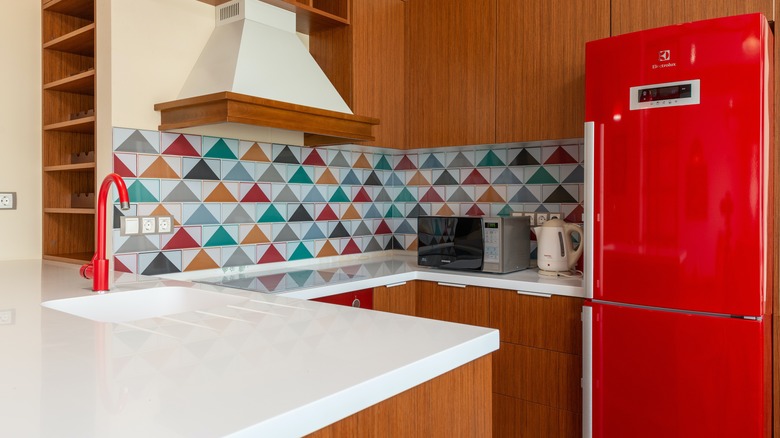 Kitchen with red refrigerator and faucet
