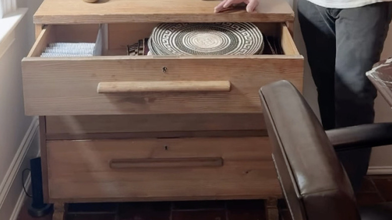 dresser in kitchen with open drawer showing storage for napkins and placemats