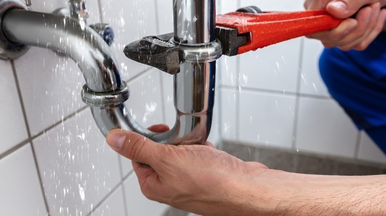Fixing pipe with red wrench