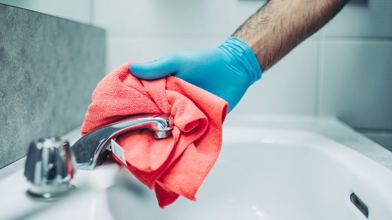 man cleaning faucet