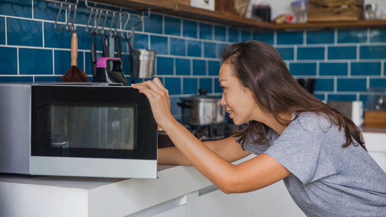 woman opening microwave
