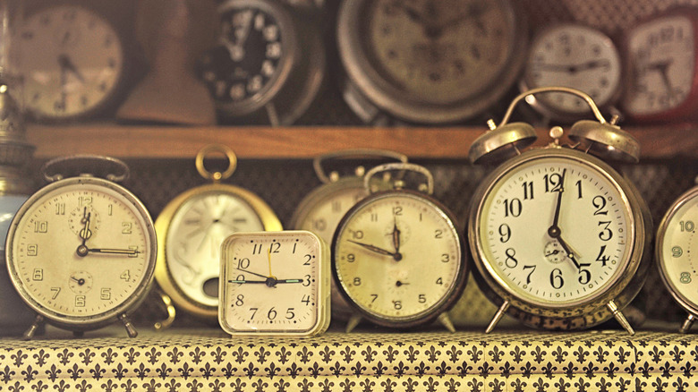 A variety of antique clocks on shelves.