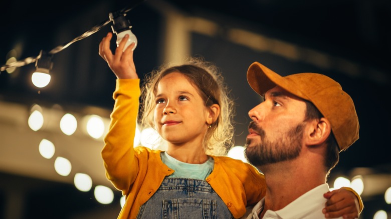 Daughter and dad fixing outdoor lights