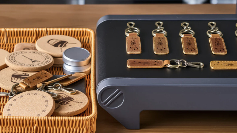 Various products produced by OMTech Solis Duo Dual Laser Engraver, including coasters and leather keychains