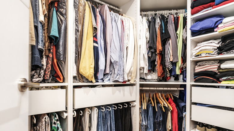 interior of closet with clothes folded and hanging inside