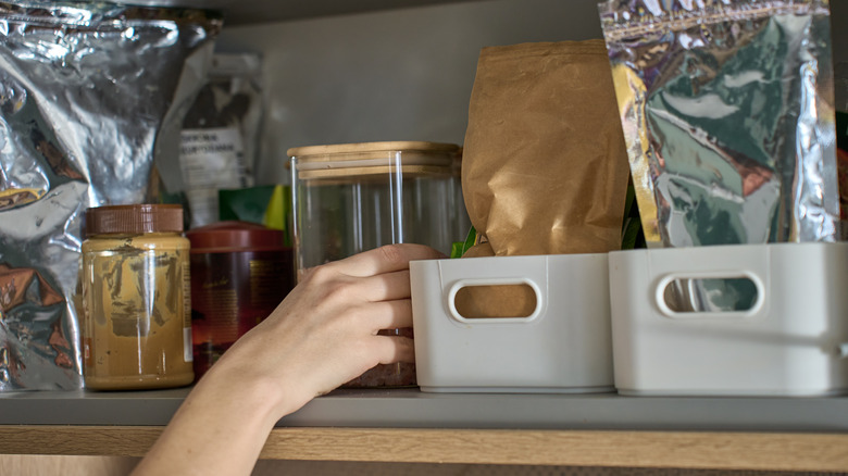 Hand placing items in pantry