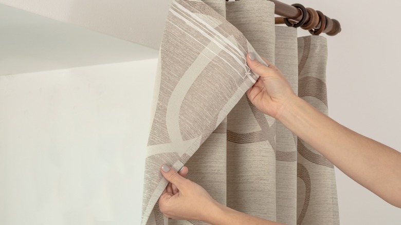 Woman hanging curtains