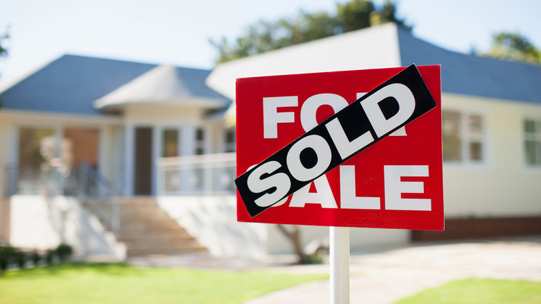 House with sold sign in front