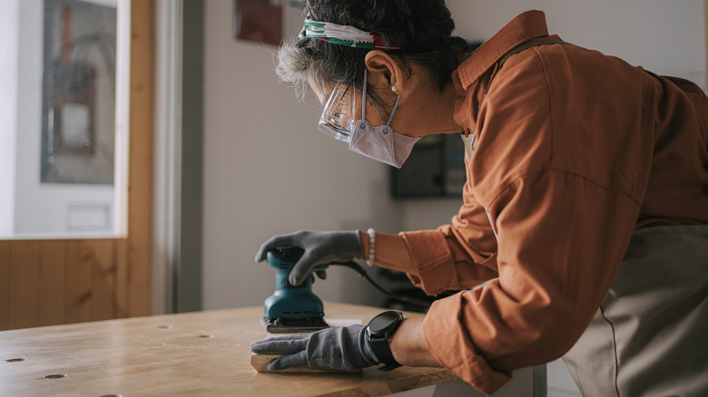 Woman sanding wood surface