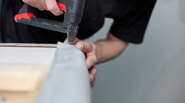 person stapling upholstery