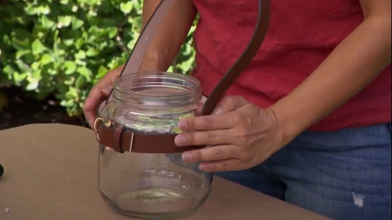Woman making belted glass jar lantern