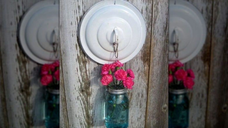 DIY fresh flower wall display using old pot lid and mason jar