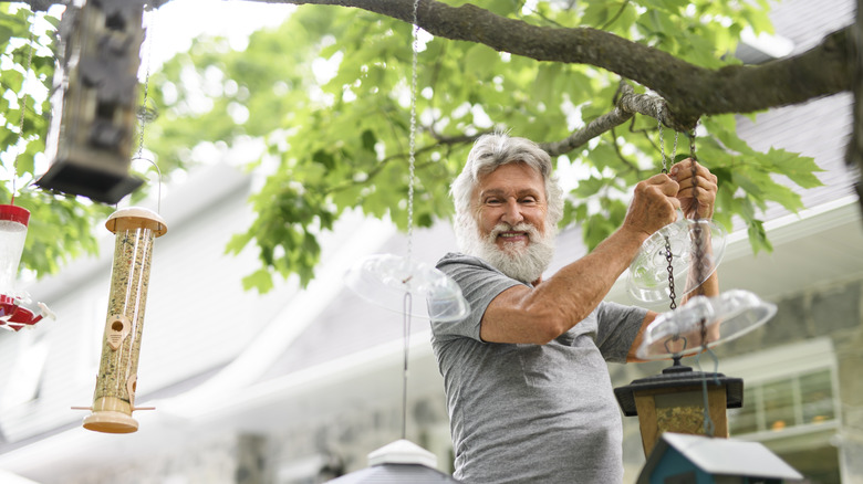 man tending to bird feeders outdoors