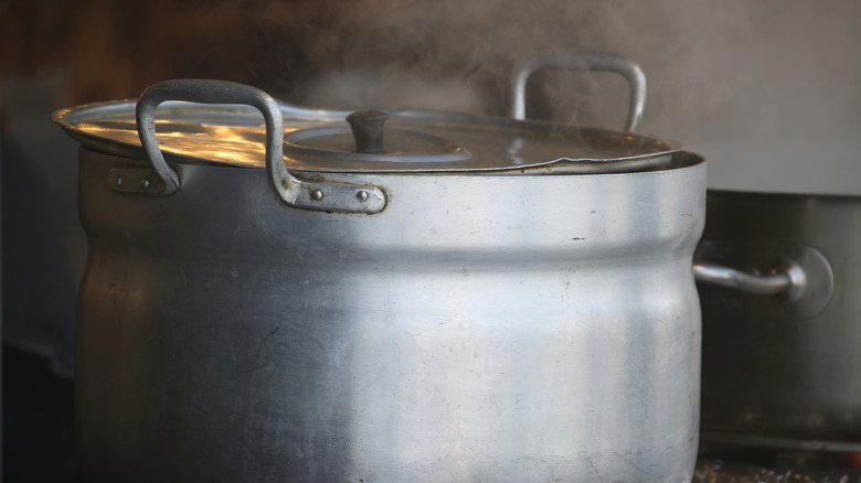 A beat-up large old pot with a lid