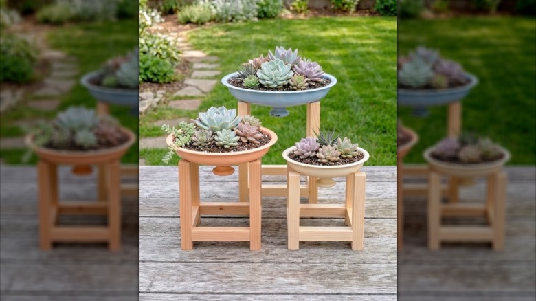 Three decorated plant stands with painted lids on a wooden surface
