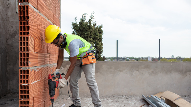 male working drilling hole in concrete