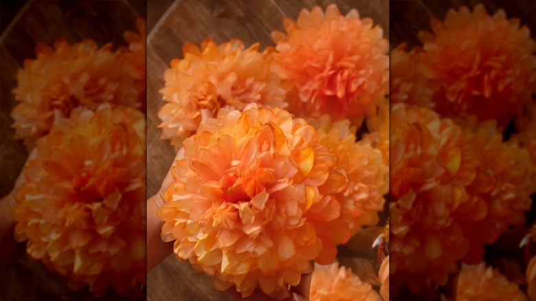 Person making paper marigolds from coffee filters