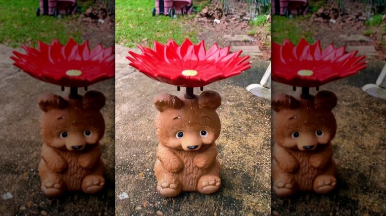 A bird bath made using a teddy bear lamp base and a flower-shaped dish.